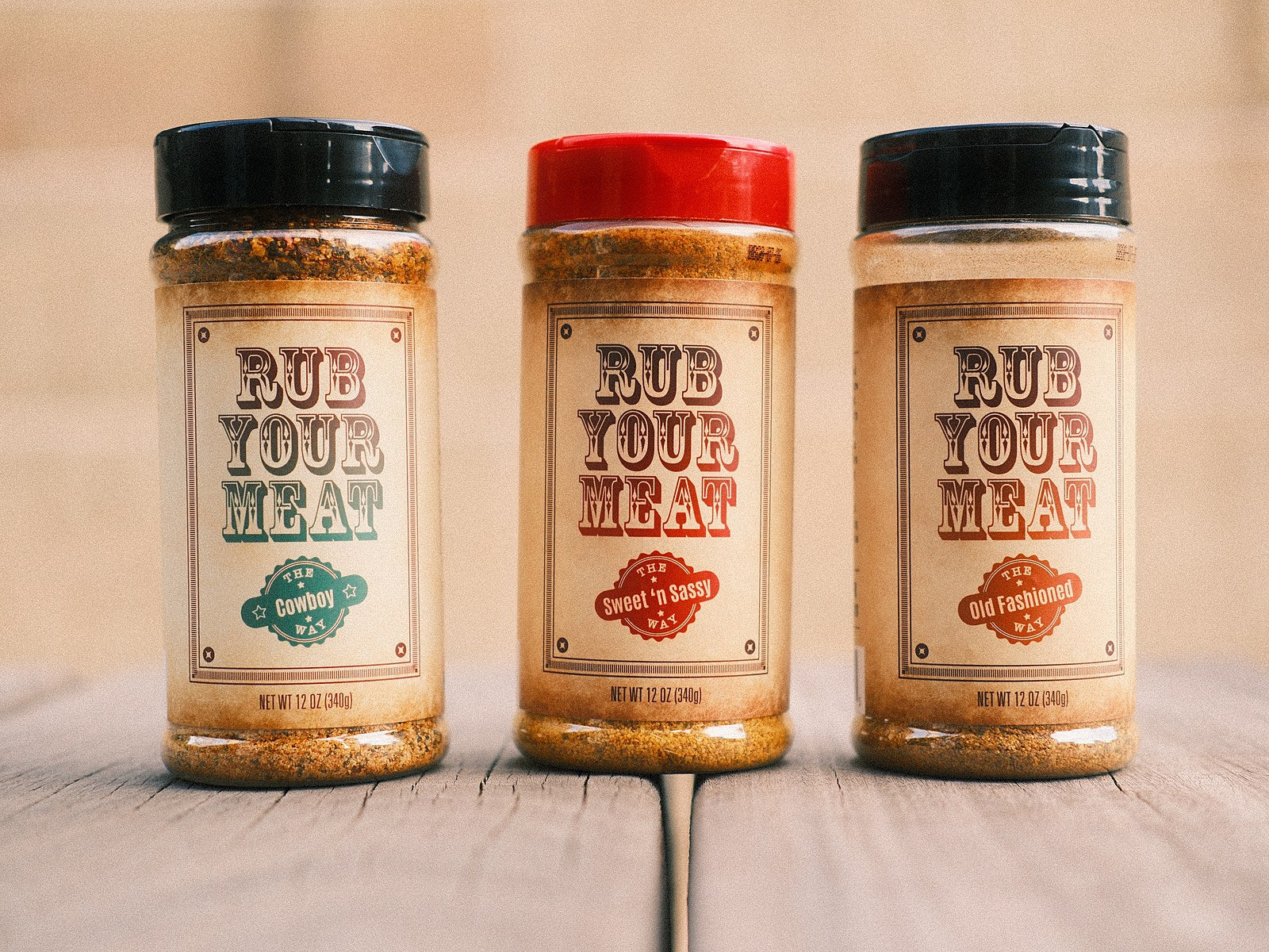 All three Rub Your Meat rubs on a wooden bench