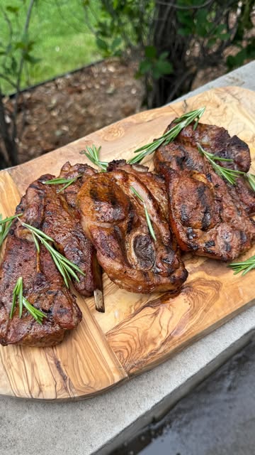 Grilled pork chops on a board with rosemary