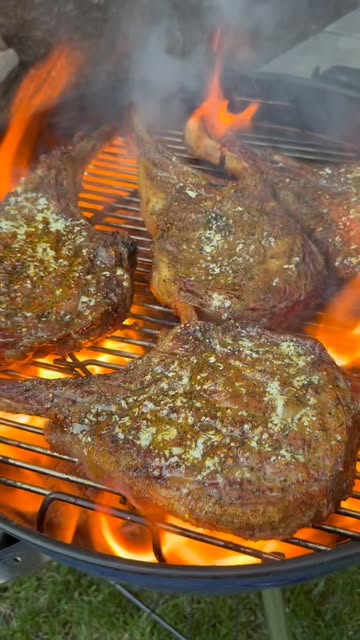 Thick steaks searing over open flame
